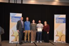 Photo of GoTriangle employees holding AdWheel Award on stage.